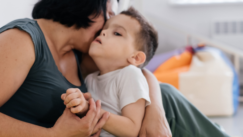 mujer con niño con discapacidad en brazos