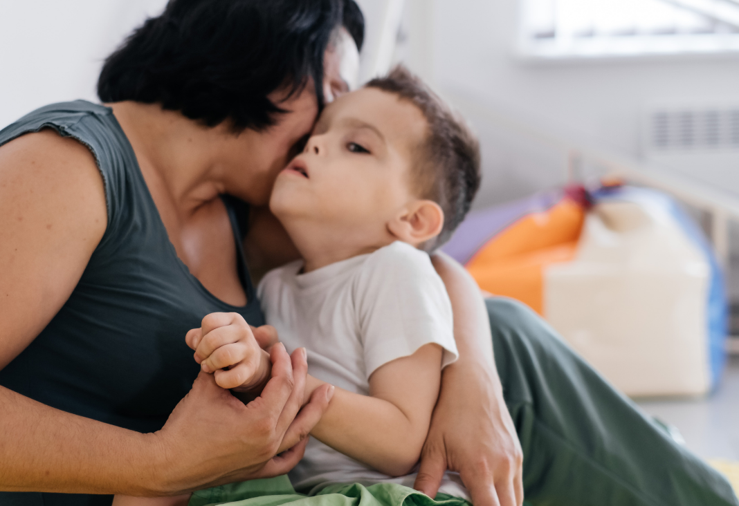 mujer con niño con discapacidad en brazos