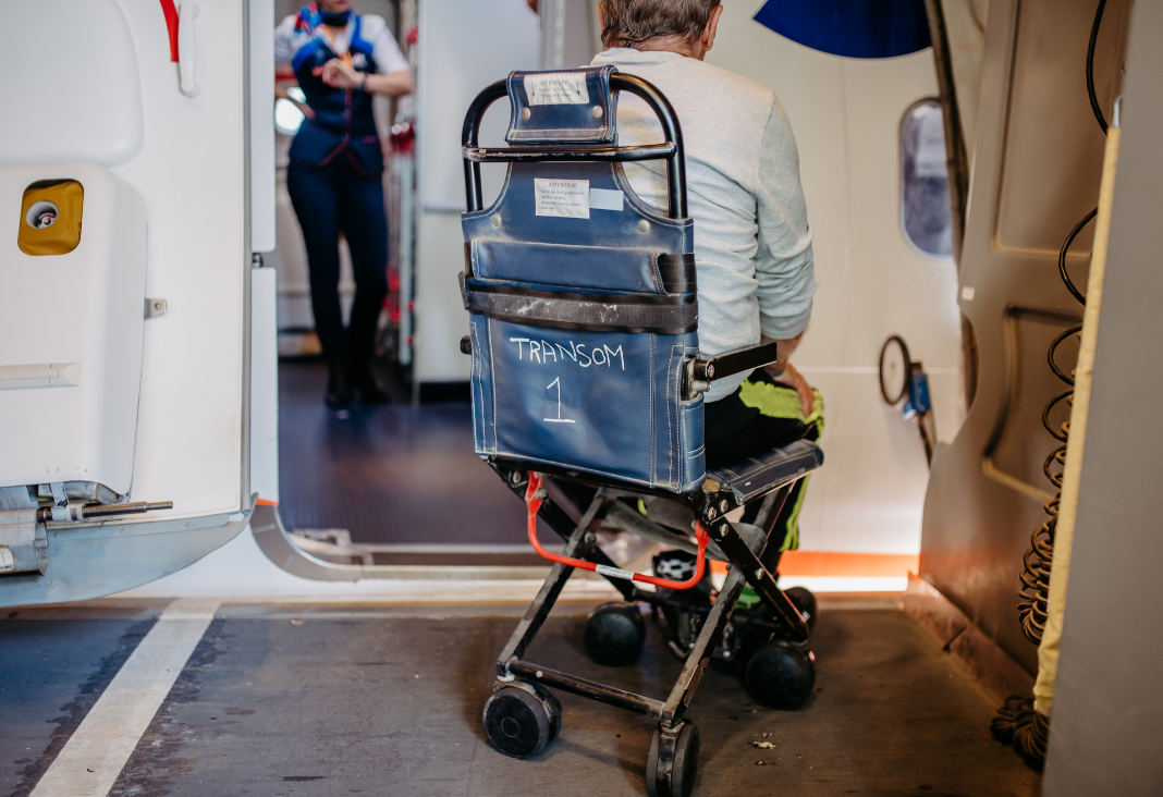 persona silla de ruedas de espalda esperando subir al avión
