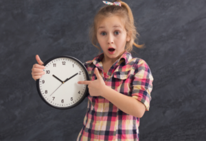 Niña con un reloj en la mano