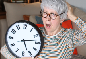 Mujer mayor con un reloj en la mano