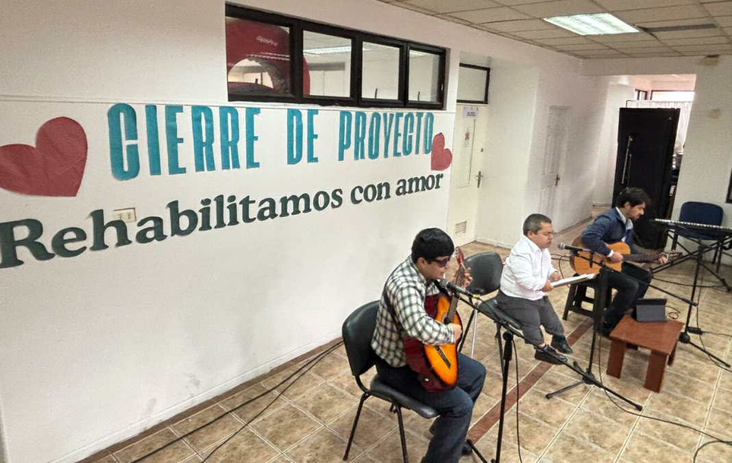 Dos personas tocando guitarra y otra de talla baja cantando
