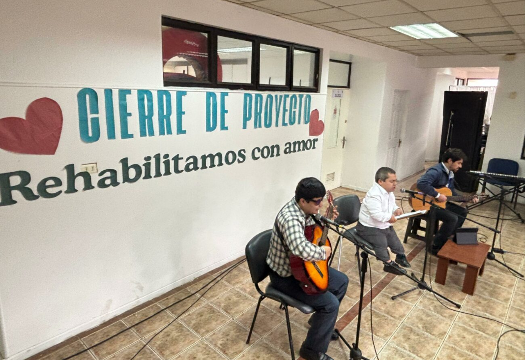 Dos personas tocando guitarra y otra de talla baja cantando
