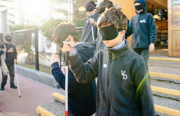 Niño con ojos vendados experimentando lo que vive una persona ciega