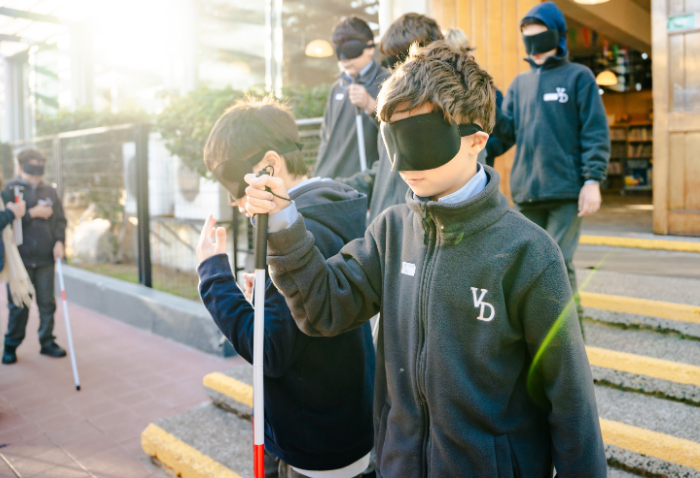 Niño con ojos vendados experimentando lo que vive una persona ciega