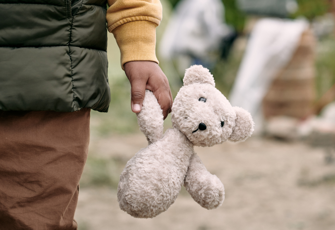 Mano de un niño sujetando un oso de peluche