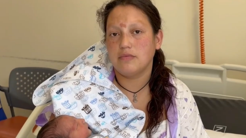 Mujer mirando de frente con su bebé en brazos