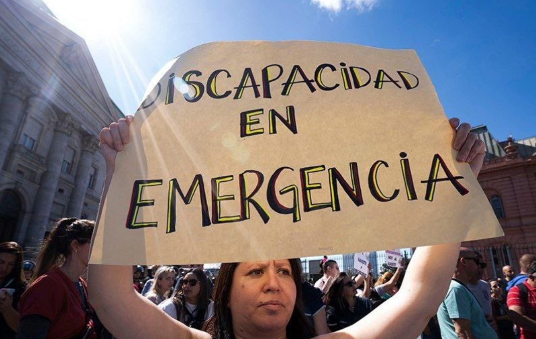 Mujer con un cartel que dice "Discapacidad en emergencia"