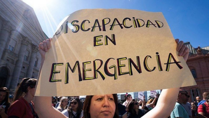 Mujer con un cartel que dice "Discapacidad en emergencia"