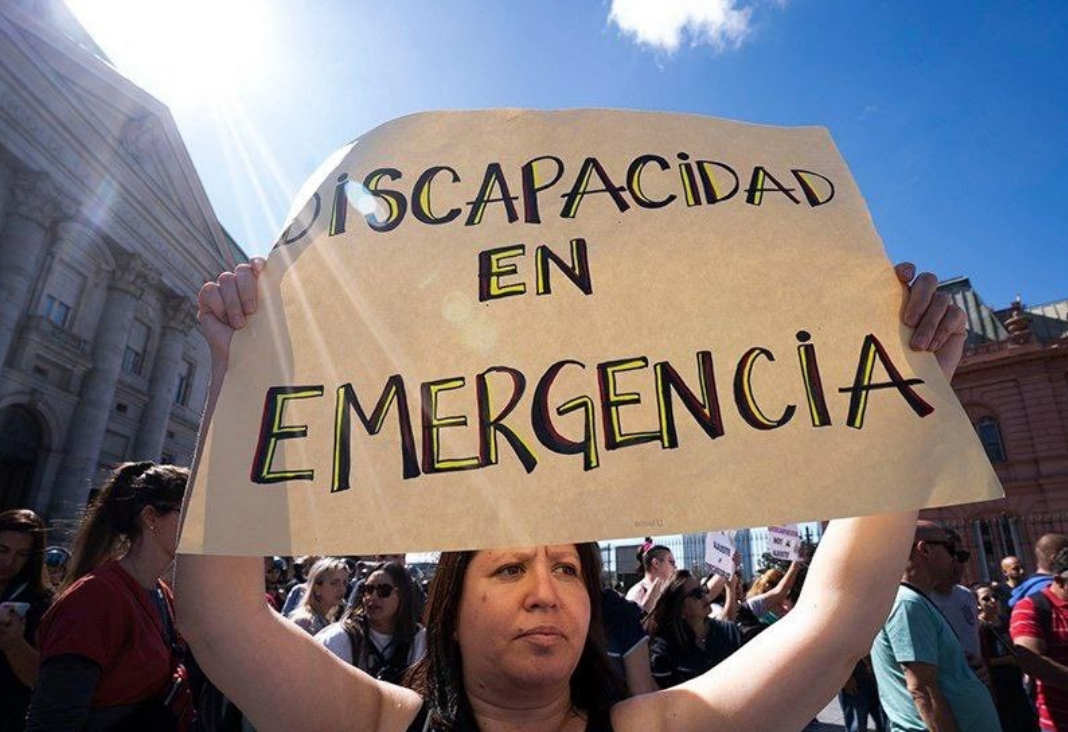 Mujer con un cartel que dice "Discapacidad en emergencia"
