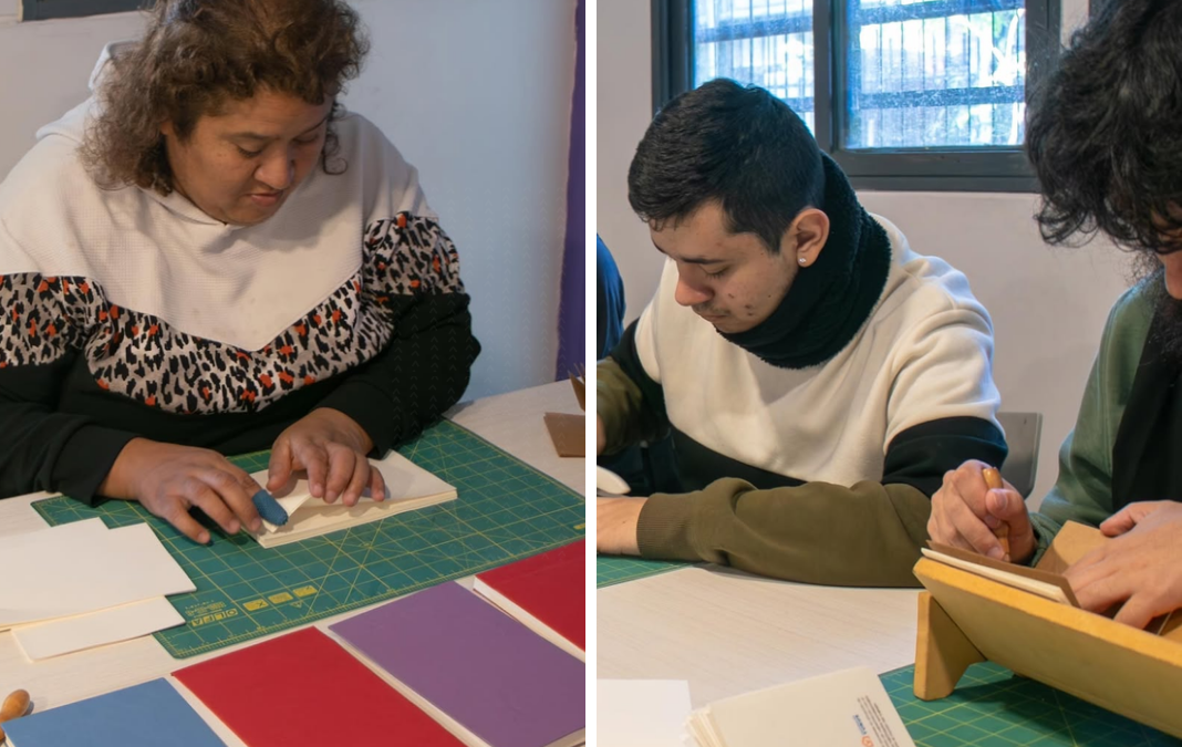 Una mujer y dos hombres encuadernando libretas