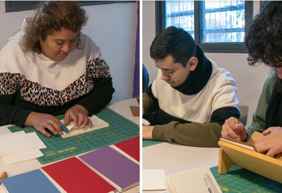 Una mujer y dos hombres encuadernando libretas