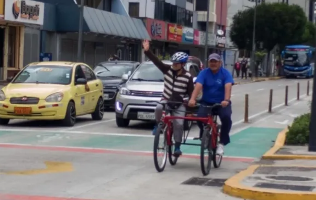 Persona ciega en bicicleta junta a un acompañante
