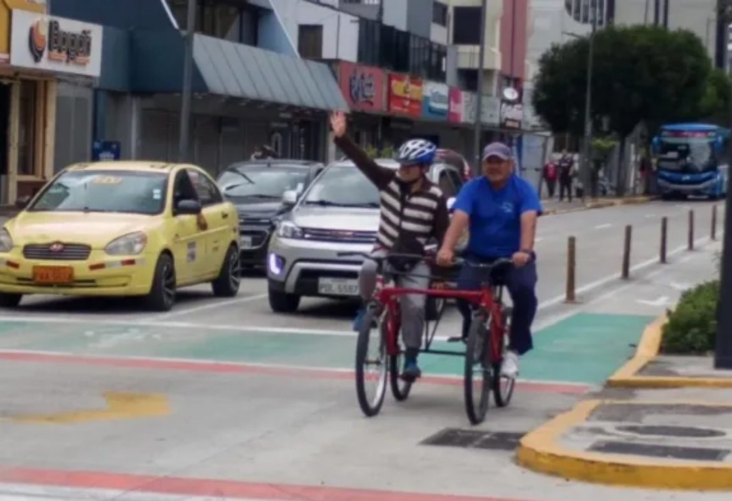 Persona ciega en bicicleta junta a un acompañante