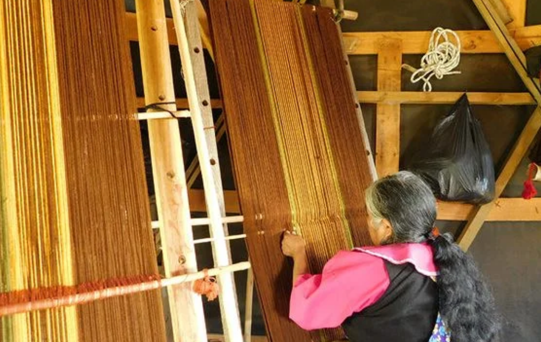 Mujer mapuche tejiendo un poncho mapuche en un telar