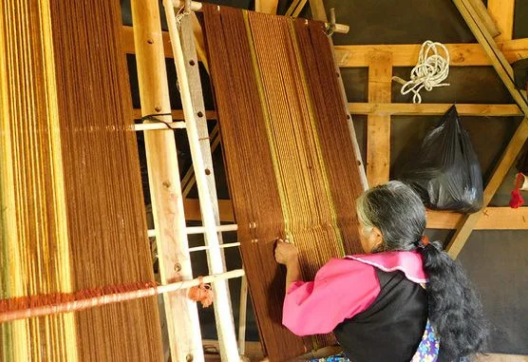 Mujer mapuche tejiendo un poncho mapuche en un telar