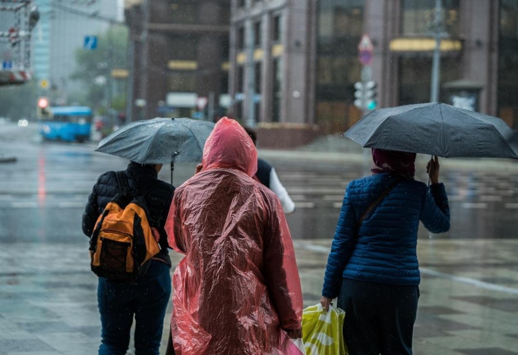 Personas esperando cruzar la calle bajo la lluvia