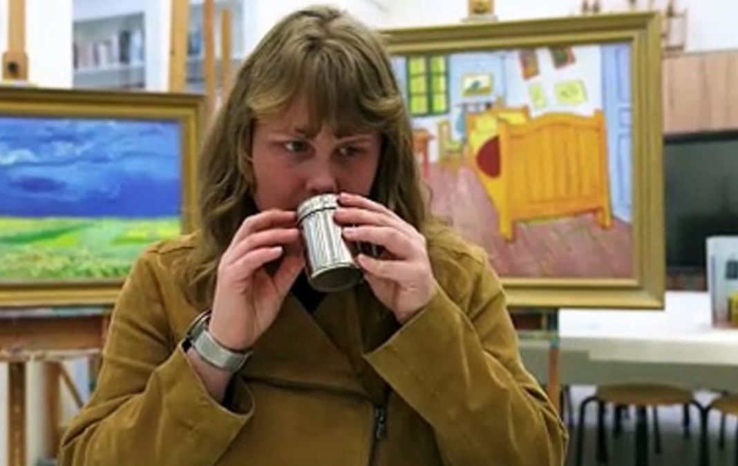 Mujer ciega oliendo una esencia y detrás dos cuadros de Van Gogh