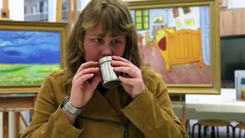 Mujer ciega oliendo una esencia y detrás dos cuadros de Van Gogh