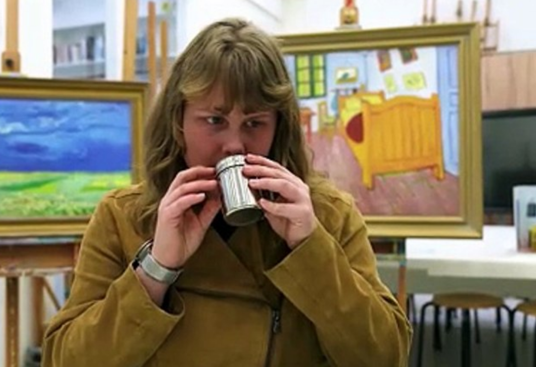 Mujer ciega oliendo una esencia y detrás dos cuadros de Van Gogh