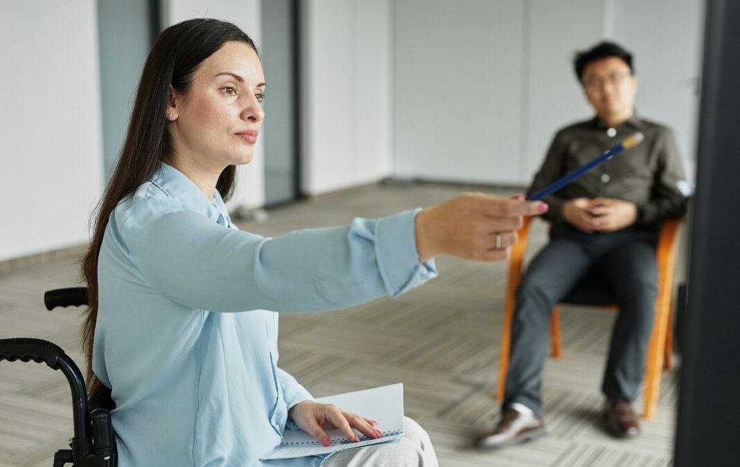 Mujer en silla de ruedas liderando una reunión