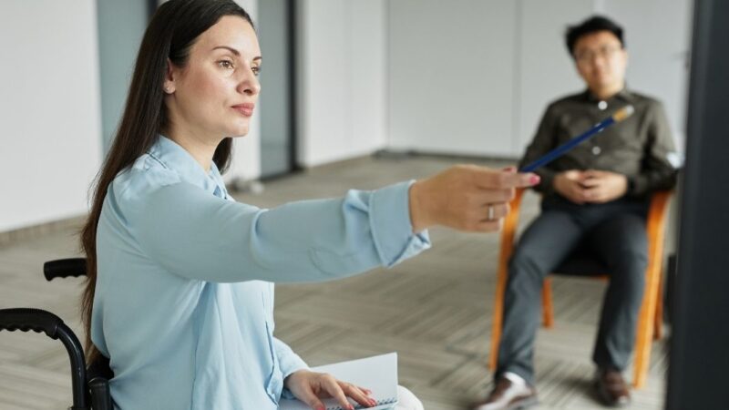 Mujer en silla de ruedas liderando una reunión