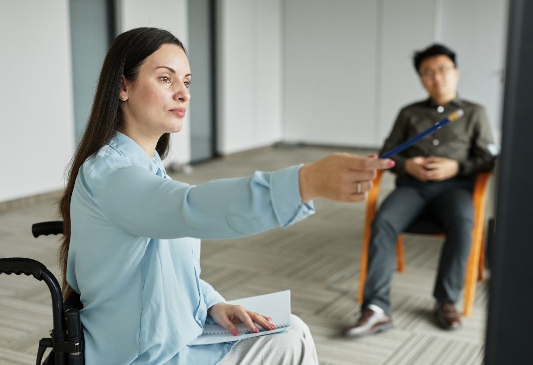 Mujer en silla de ruedas liderando una reunión