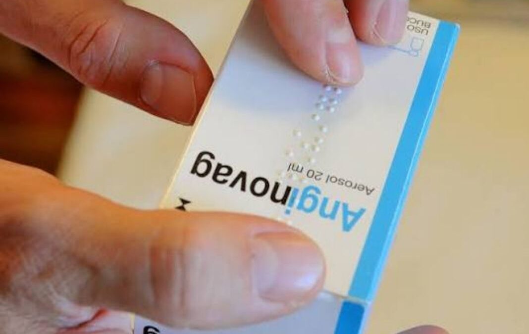 Caja de medicamento con texto en braille y una mano leyendo