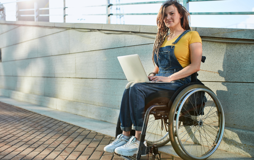 mujer en silla de ruedas con un notebook