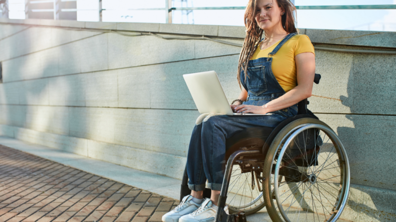 mujer en silla de ruedas con un notebook