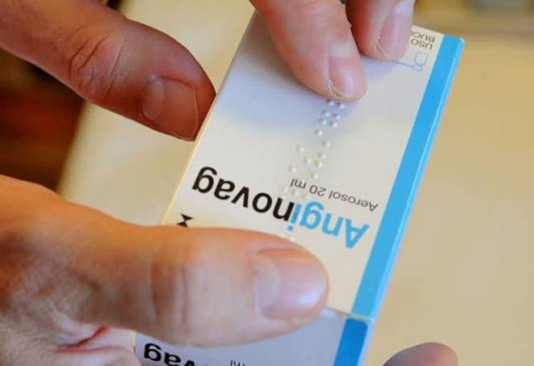 Caja de medicamento con texto en braille y una mano leyendo