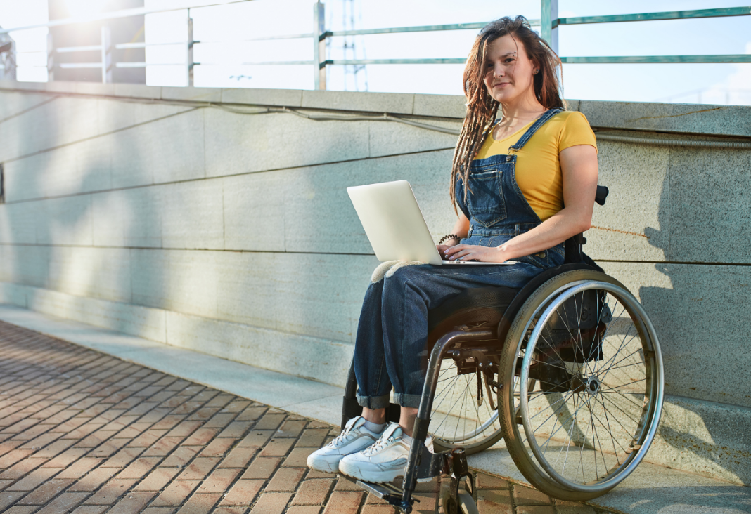 mujer en silla de ruedas con un notebook