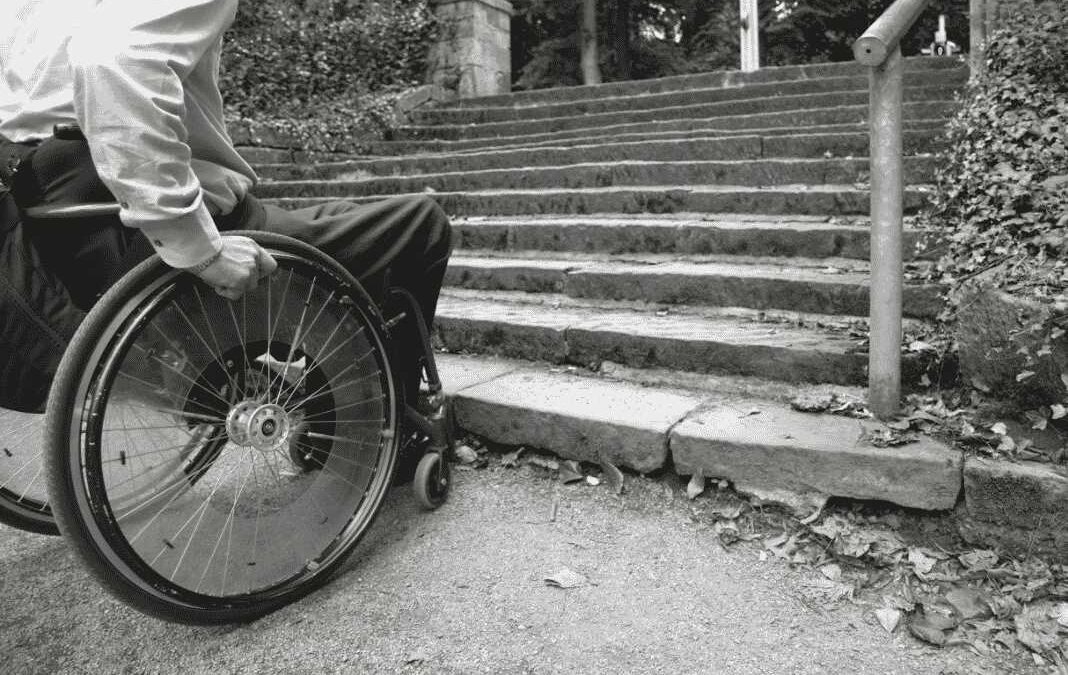 Imagen de persona en silla de ruedas al borde de una escalera