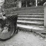 Imagen de persona en silla de ruedas al borde de una escalera