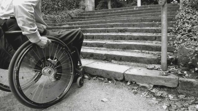 Imagen de persona en silla de ruedas al borde de una escalera