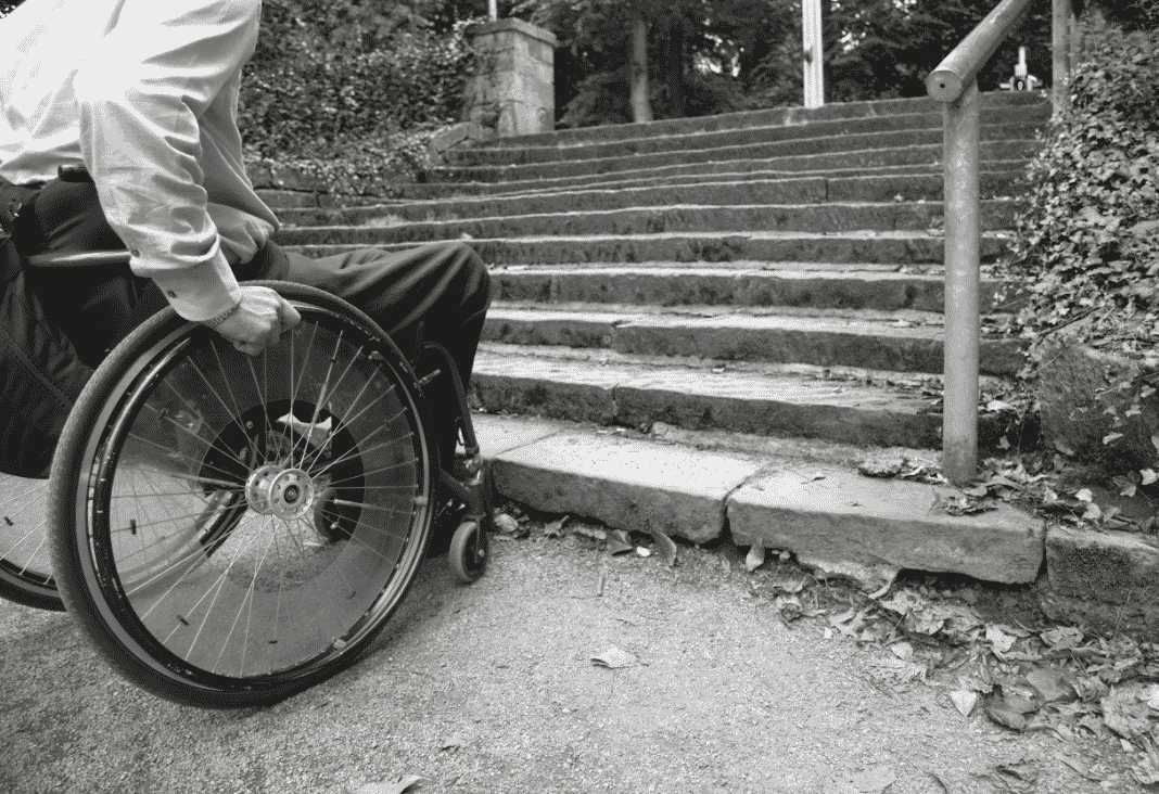 Imagen de persona en silla de ruedas al borde de una escalera