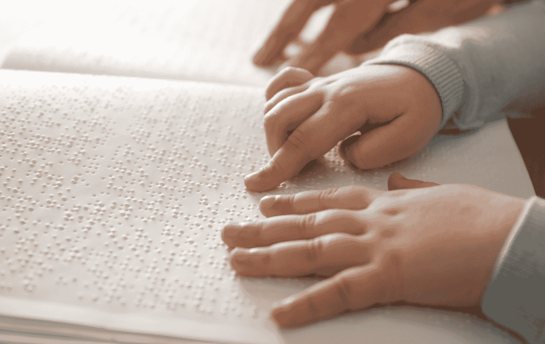 manos de niño leyendo un libro en braille