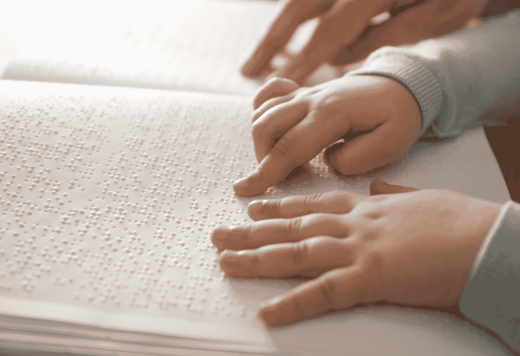 manos de niño leyendo un libro en braille