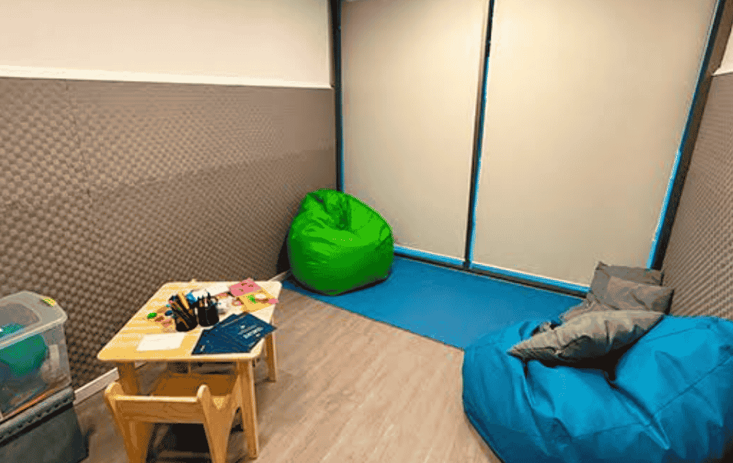 Sala de calma con unos puff, una mesa y diversos objetos para dibujar