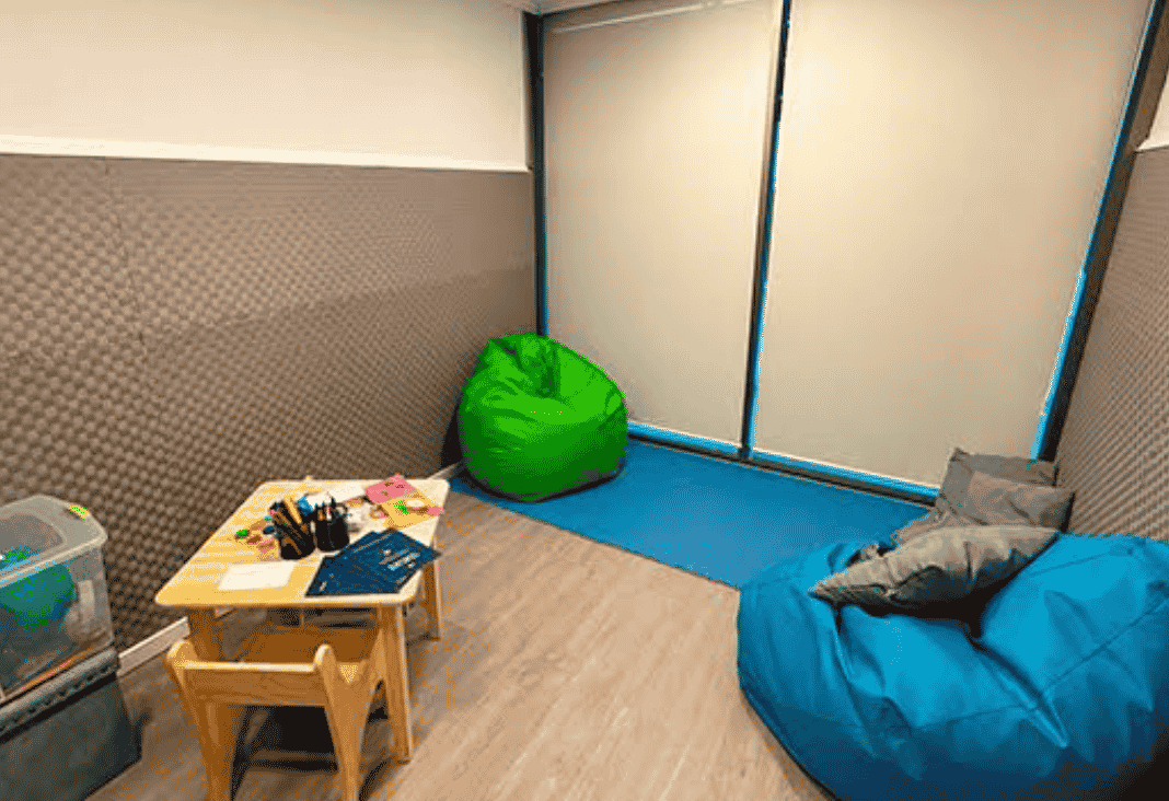 Sala de calma con unos puff, una mesa y diversos objetos para dibujar