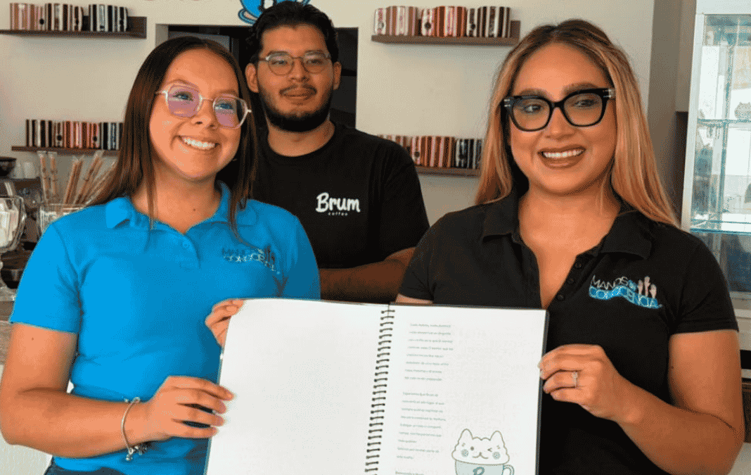 Dos mujeres y un hombre mostrando un menú escrito en braille