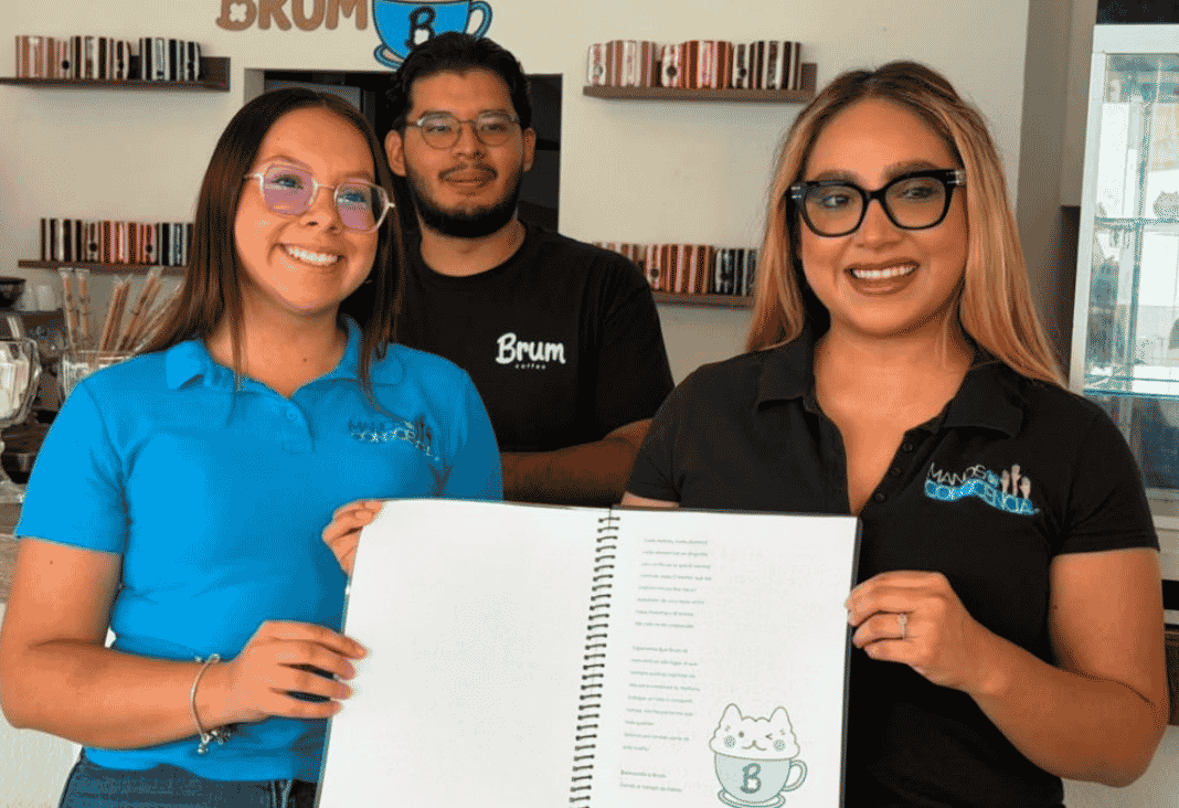 Dos mujeres y un hombre mostrando un menú escrito en braille