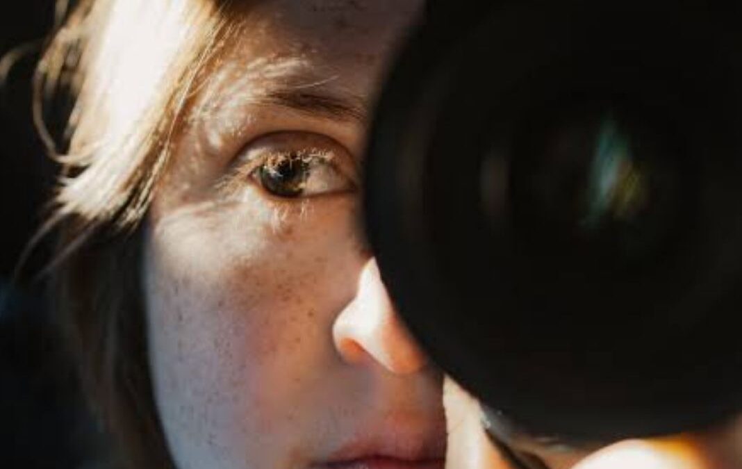 mujer con un lente de cámara fotográfica