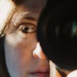 mujer con un lente de cámara fotográfica