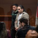 hombre esposado en sala de tribunales