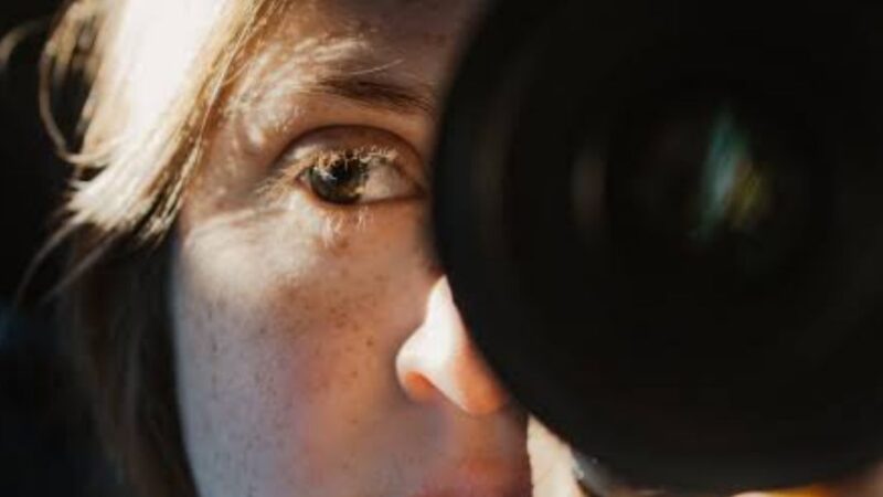 mujer con un lente de cámara fotográfica