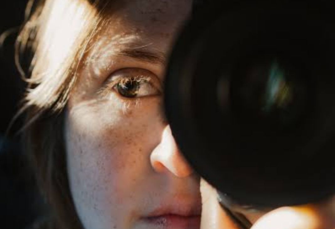 mujer con un lente de cámara fotográfica