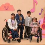 dos niños y dos niñas modelando ropa adaptada