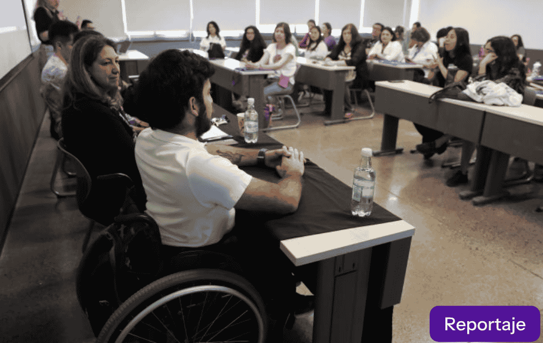 Hombre en silla de ruedas exponiendo en una sala universitaria