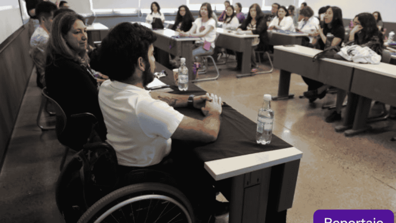 Hombre en silla de ruedas exponiendo en una sala universitaria